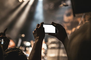 koncert, chytrý telefon, živá hudba, zachycení, živá scéna, ruce hospodářství, černý smartphone, koncertní zážitek, publikum, jevištní světla, fotografování událostí