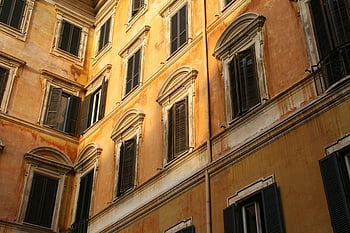 brown wall painted, warm-toned facade, historic European architecture, classic shuttered windows, European building, warm colors, architectural details, old building, European style, shutters, historic building
