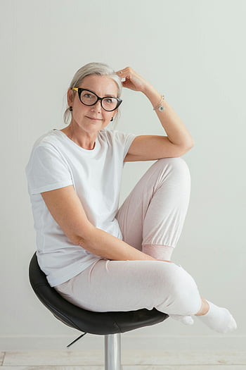 donna anziana, camicia bianca, sorridente, seduto sulla sedia, donna senior, occhiali, vestiti casuali, seduto all'interno, Posa rilassata, impostazione interna, sfondo bianco