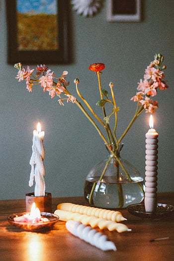 candles, table decoration, flowers in vase, cozy still life, wooden table, candlelight, floral arrangement, home decor, ambient lighting, rustic setting, table setting