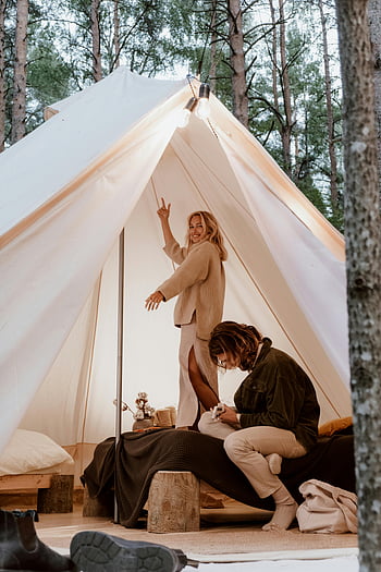 žena ve stanu, Kempovací dobrodružství, Útulný stan, Woods kempování, mladý pár, užívá si kempování, stan v lese, venkovní dobrodružství, Glamping Experience, lesní kempování, Interiér stanu