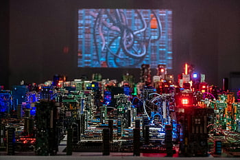 computer hardware, miniature cityscape, circuit boards, vibrant lighting, technological display, electronic components, close-up, tech art, futuristic design, illuminated circuits, digital art