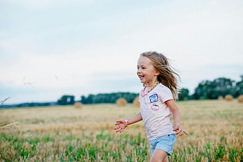 smiling girl, running, green field, joyful child, summer field, fun, freedom, outdoor activity, happy childhood, nature play, carefree moment