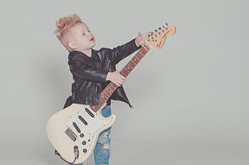boy, black jacket, electric guitar, mohawk, strumming, leather jacket, blue jeans, stylish, young boy, playing guitar, white guitar