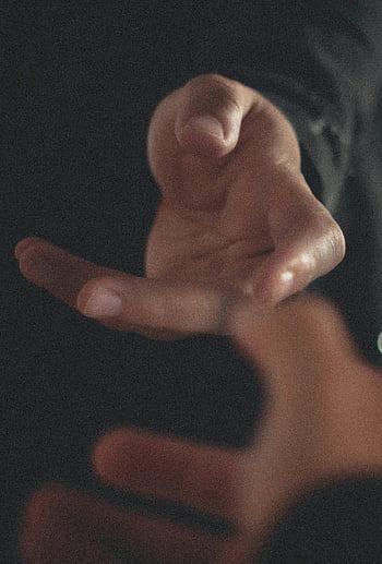 Pár plodin, něžně se dotýká rukou, Skvělý okamžik, ruce dosáhly, romantické gesto, intimní připojení, Detailní ruce, emocionální dotek, lidské spojení, měkké zaostření, černé pozadí