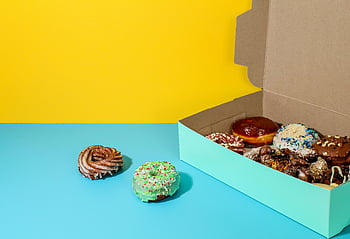 box of donuts, assorted donuts, vibrant display, colorful backdrop, donut box, assorted flavors, donut assortment, colorful donuts, donut variety, donut display, donut collection