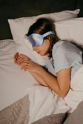 schlafende Frau, Augenmaske, Bequemes Bett, Entspannung, sich ausruhen, friedlicher Schlaf, Bettruhe, erholsamer Schlaf, Schlafmaske, gemütliches Bett
