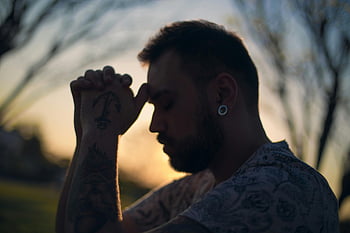 tetovaný muž, klidná rozjímání, Profil západu slunce, bílé tričko s posádkou krku, vousy, Piercing ucha, tetování paže, venkovní scénu, klidný okamžik, přirozené světlo, kontemplativní pozice