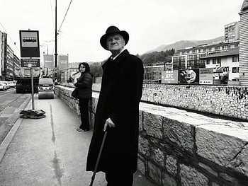 Sarajevo, Bosnia, street scene, black and white, daily life, bustling street, candid photo, urban life, man with cane, woman waiting, cityscape