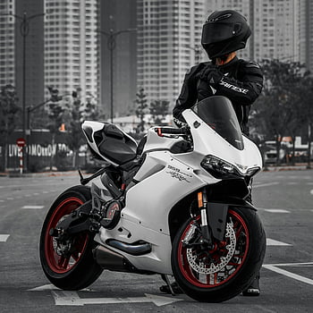 man in black jacket, white sports bike, Ducati Panigale, motorbike rider, full gear, urban setting, motorcycle, red wheels, helmet, street, cityscape