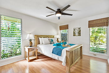 sunny tropical bedroom, wooden furniture, teal accents, lush greenery views, tropical bedroom decor, wooden bed frame, bedside table, ceiling fan, natural light, tropical plants, bedroom interior design