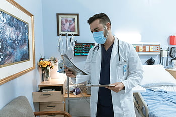 doctor, face mask, X-ray film, hospital room, patient diagnosis, medical professional, healthcare setting, medical equipment, patient care, medical examination, healthcare worker