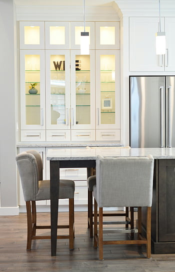 kitchen interior, white cabinets, minimalist decor, contemporary kitchen, gray chairs, wooden floor, clean design, modern kitchen, glass shelves, stainless steel refrigerator, marble countertop