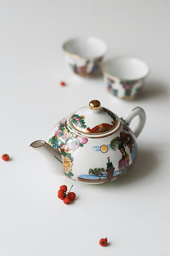 Teiera in porcellana, Teiera decorativa, tazze abbinate, design artistico, sfondo bianco, set di teiere, Tazze di porcellana, disegno floreale, progettazione del paesaggio, arte della teiera, set di tazze
