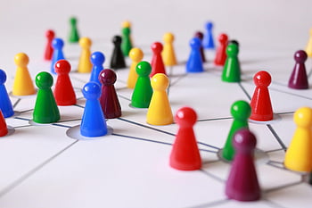 colorful pawns, game board, networking, teamwork, strategic arrangement, close-up photography, white lined surface, plastic cones, multi-colored pieces, board game, connection network