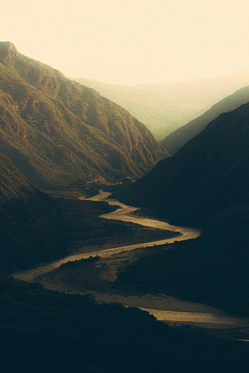 river flowing in mountains, winding river, majestic mountains, valley, dusk, captivating landscape, mountain river, natural scenery, scenic view, mountain valley, river at dusk