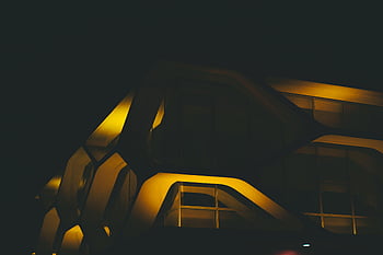 moderne bygning, futuristisk design, dramatisk belysning, opplyst bygning, nattfotografering, arkitektonisk fotografering, moderne arkitektur, urbane landskap, svart og gul, natt scene, bybildet