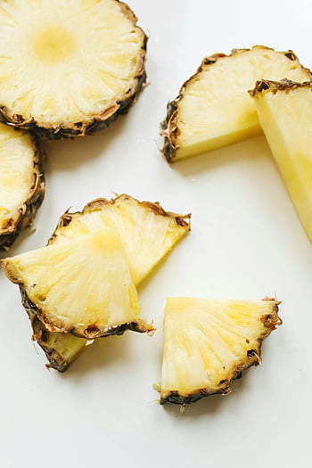 sliced pineapple, pineapple slices, juicy pineapple, vibrant yellow, close-up pineapple, pineapple texture, pineapple fruit, pineapple pieces, pineapple chunks, pineapple close-up, pineapple segments