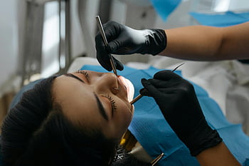undersøker tennene, Nærbilde-tannundersøkelse, profesjonell tannpleie, tannhelse, Pasienttenner, dental verktøy, tannhansker, tannstol, tannlegeklinikk, tannhygiene, Tannkontroll