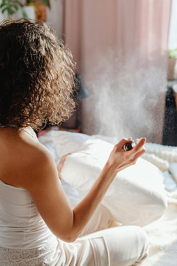 donna che spruzza il cuscino, spray per aromaterapia, rilassamento, Accogliente impostazione interna, spray per cuscini, cura di sé, Camera da letto, comfort, benessere, rilassamento a casa, aromaterapia
