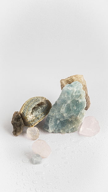 Kristalle, weiße Oberfläche, heilende Kristalle, Steine, natürliche Schönheit, Nahaufnahme, weißer Hintergrund, verschiedene Kristalle, Kristallsammlung, Steinanordnung, Mineralienausstellung