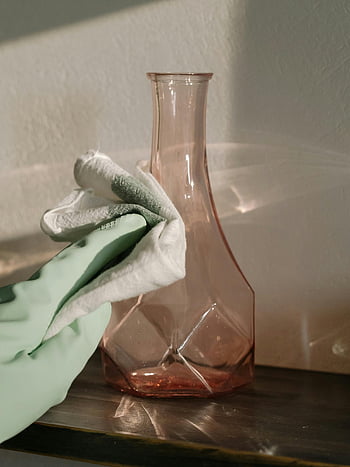 glass vase, cleaning gloves, cozy home, close-up, green and white textile, clear glass, home touch, cleaning process, household chores, domestic scene, hand gloves