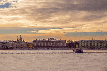 St Petersburg, frozen Neva River, historic buildings, serene winter scene, gray concrete building, body of water, cloudy sky, riverfront architecture, winter landscape, cityscape, waterfront view