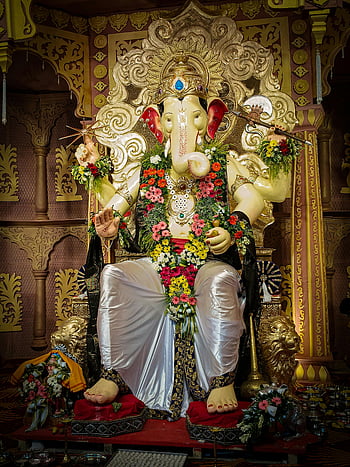 Statua di Ganesh, impostazione del tempio, tradizioni culturali vibranti, Ganesh adornato, tradizioni culturali, arredamento del tempio, statua religiosa, divinità indiana, decorazioni floreali, arte del tempio, iconografia spirituale