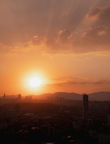dramatic sunrise, Mexico City skyline, warm sky, cityscape, urban landscape, sunrise over city, dramatic sky, morning view, city at dawn, urban sunset, city horizon