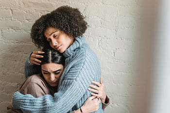 Black woman, comforting friend, emotional support, two women embracing, indoor comfort, emotional connection, supportive hug, upset friend, indoor scene, emotional bond, friendship moment