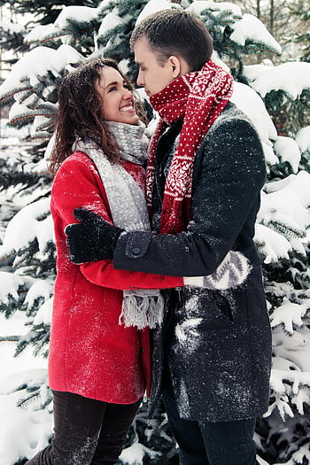 amici felici, foresta innevata, abbraccio amorevole, scena invernale, coppia nella neve, cappotto rosso, moda invernale, alberi coperti di neve, inverno all'aperto, felicità nella neve, coppia d'inverno