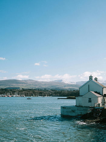 House by the Sea, Bangor, Wales, seascape, coastal houses, waterfront property, seaside view, coastal living, seaside town, mountain backdrop, boats in water
