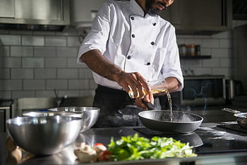 chef, professional kitchen, pouring oil, frying pan, cooking, man cooking, kitchen, food preparation, culinary arts, chef uniform, steam rising