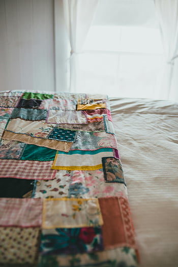 patchwork quilt, colorful quilt, handmade quilt, bed, softly-lit room, detailed view, floral patterns, vintage quilt, cozy bedroom, textile art, home decor