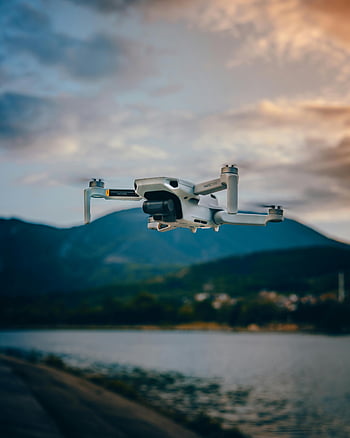 drone flying, mountain lake, sunset clouds, nature and technology, professional drone, white drone, mountain landscape, aerial photography, scenic view, outdoor technology, drone photography