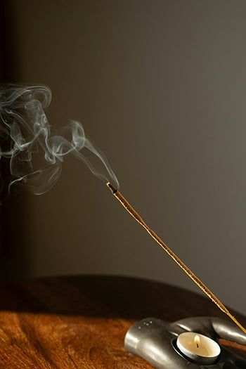 burning incense stick, tealight candle, calming ambiance, close-up, smoke, incense, candle, relaxation, aroma, meditation, tranquility