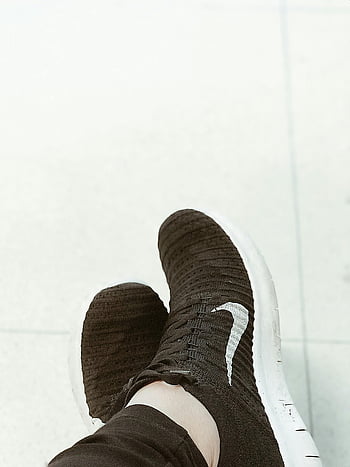 Nike Running Shoes, black knit sneakers, casual fashion footwear, close-up, pavement, Nike logo, sportswear, athletic shoes, footwear style, knit material, white soles