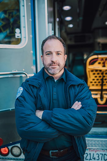 paramedic, arms crossed, ambulance, confident stance, emergency responder, medical professional, uniform, outdoor portrait, rescue worker, healthcare worker, emergency services