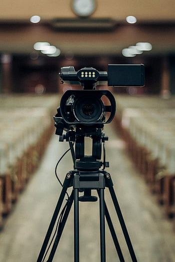 camera on tripod, professional video camera, tripod, empty auditorium, front view, video camera, auditorium, camera, professional camera, video production, recording equipment