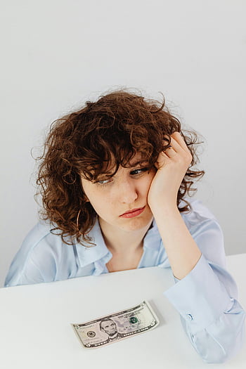 curly-haired woman, financial problem, worried expression, dollar bill, financial issues, contemplation, caucasian woman, curly hair, financial stress, money concerns, financial worry