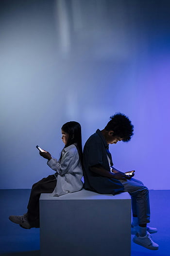 Kinder, die Smartphones verwenden, Rücken an Rücken, Bildschirm Licht, Dark Studio, minimale Einstellung, Kinder mit Telefonen, Beleuchtete Bildschirme, auf Würfel sitzen, Moderne Technologie, Jugend -Engagement, Digitale Interaktion