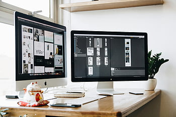 Silver iMac, Black iMac, dual monitors, office workspace, stylish desk, decorative plant, keyboard, notebooks, modern office, tech setup, workspace design