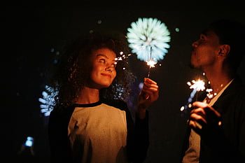 Couple tenant des cierges magiques, jeune couple, célébrer, cierges magiques, feux d'artifice, nuit, de fête, moment joyeux, célébration en plein air, scène romantique, Célébration de vacances