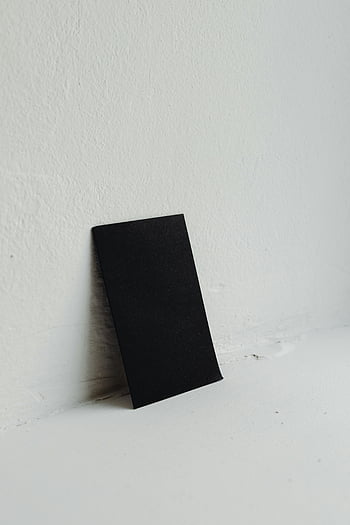 černý papír, bílé zdi, vizitka, stojící, dostatek prostoru pro kopie, minimalistický design, jednoduché složení, Černý a bílý, čisté pozadí, produktová fotografie, studio shot