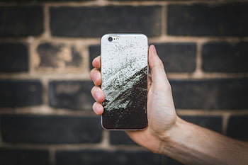 smartphone, black and grey phone case, artistic phone case, hand holding phone, dark brick wall, unique phone case, smartphone case, phone accessory, modern phone case, stylish phone case, phone design