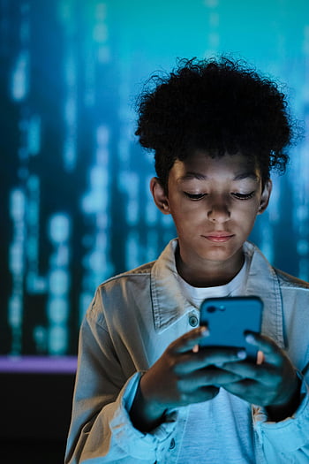 boy, smartphone, young boy, tech-inspired background, focused, using smartphone, digital background, child technology, mobile device, technology use, blue background