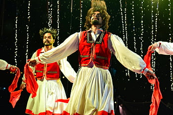 two dancing men, stage performance, traditional costumes, vibrant dance, cultural expression, dynamic motion, stage dance, cultural dance, traditional dance, stage costumes, cultural costumes