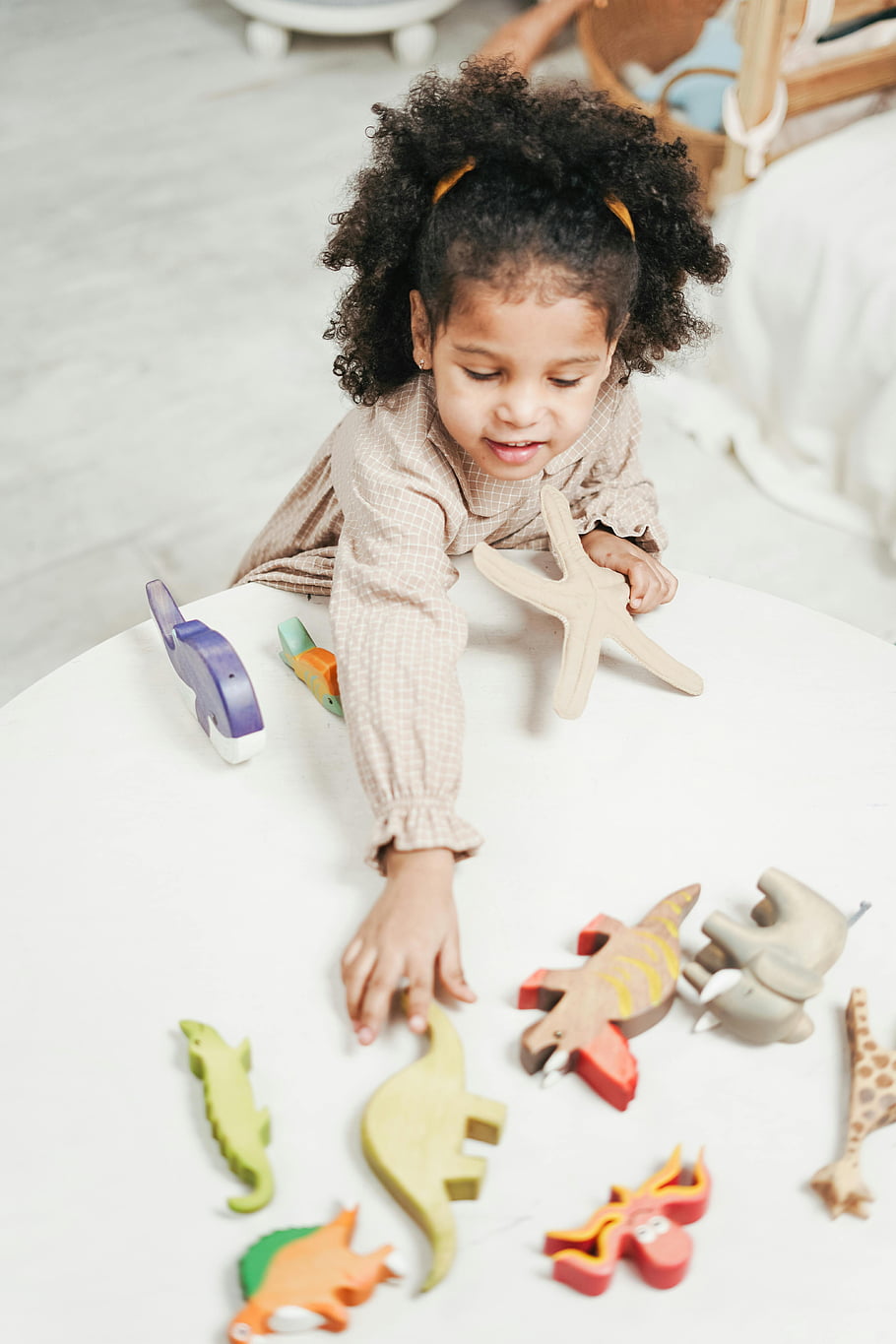 spielen, Holzspielzeug, buntes Spielzeug, Tierspielzeug, gemütliches Zimmer, fröhliches Kind, Spielzeit, Indoor-Spiel, Kinderspielzeug, Bildungsspielzeug, hölzerne Dinosaurier