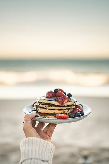 pancakes, berries, beach, breakfast, plate, strawberries, blueberries, person holding, perfect setting, seaside, morning meal