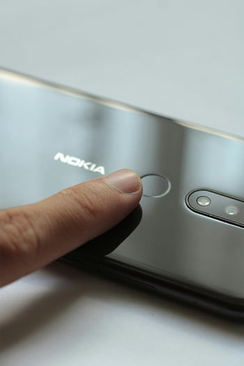 fingerprint scanner, Nokia smartphone, secure access, close-up finger, smartphone security, Nokia phone, biometric authentication, mobile security, touch sensor, smartphone technology, silver Nokia